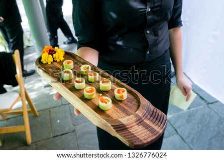 a waiter holding a wooden platter full of vegetarian appetizers - wedding catering series