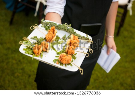a waiter holding a plate of mini fried chicken and waffles - wedding catering series