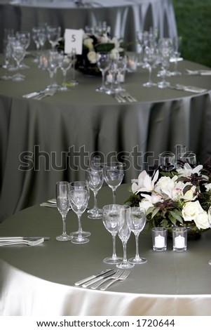a typical dinner table setting, with a shallow depth of field with the focus on the foreground table, with the other tables fading out of focus