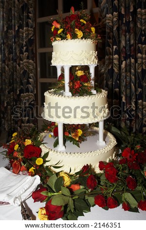 a three tiered yellow wedding cake with roses