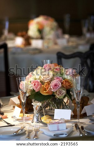 table setting for a wedding or dinner event, very shallow depth of field with the focus on the flowers, blurry background.