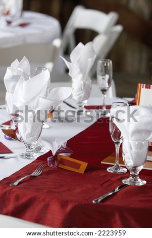 Wedding table set for fine dining with red table clothe and blank name cards