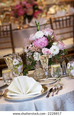 tables set for fine dining during a wedding event. Shallow depth of field, focus on the bouquet of flowers
