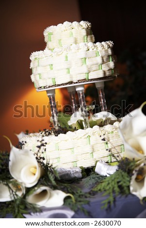 stock photo Wedding cake on a table with candles and white flowers