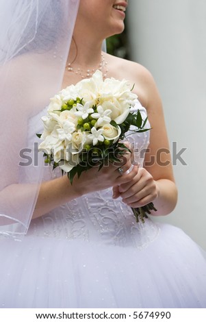 A brides wedding bouquet of flowers being held in her hands. White flowers are pretty!