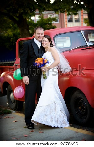 happy bride and groom with an old red truck