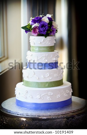 stock photo A large multi level wedding cake with purple flower topper