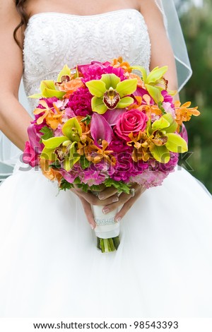 Wedding bouquet of flowers held by a bride. Pink, Orange, and Green