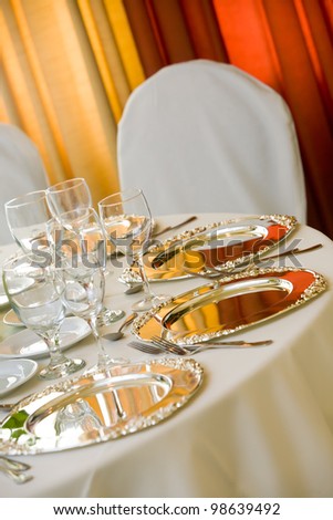 wedding table with white tablecloth and silver platters set for fine dining