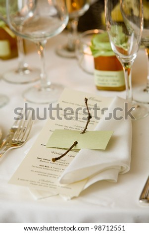Wedding tables set for fine dining or another catered event. Menu with a blank name tag