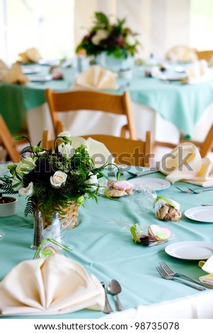 a blue wedding table with cookie favors and flower centerpieces