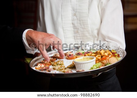 A waiter serving guests appetizers during a wedding or other catered event