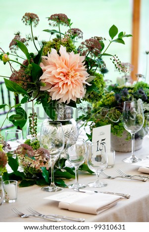 a wedding table set for fine dining with a pretty flower centerpiece