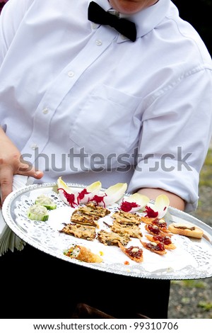 A waiter serving appetizers during a catered wedding or other banquet function