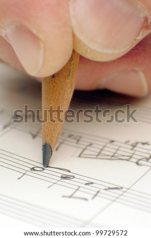 composing musical notes, writing a song with a pencil on paper