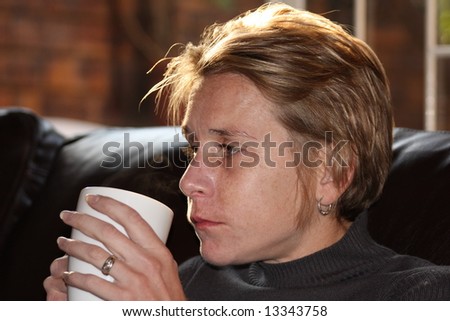 Woman drinking coffee in the morning with sun rising