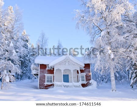 Rural building located in a opening in a forest. Pure wooden lodge in winter snow.