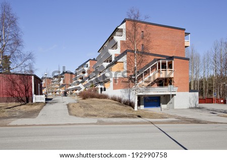 UMEA, SWEDEN ON APRIL 11. Modern flats and surrounding in sunny spring on April 11, 2014 in Umea, Sweden. Street this side. Unidentified man this side the car.