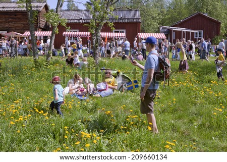 UMEA, SWEDEN ON JUNE 06. People celebrating the Swedish National Day on June 06, 2014 in Umea, Sweden. Unidentified people in the park next to Gamlia Homestead.