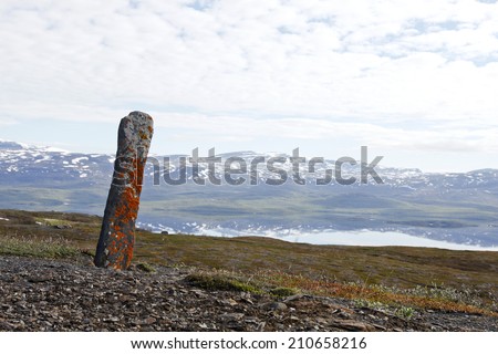 Sejte, a holy stone among the Lapps, Sami in the northern provinces. The Seite stands on a hill this side a lake. Mountains in the background.