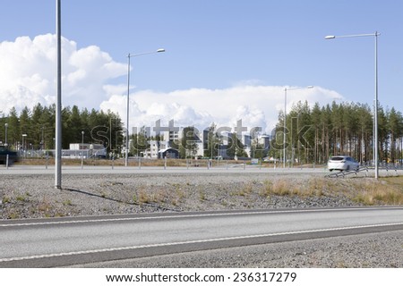 UMEA, SWEDEN ON JULY 18. Newly built Euro-route E4 on July 18, 2014 in Umea, Sweden. Modern Euro-route E4 outside the town. Buildings in the suburb to the left.