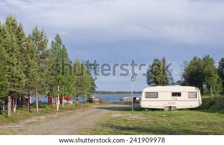 BALTIC SEA, SWEDEN ON JUNE 30. Caravan in evening lit by the sea on June 30, 2011 in The Baltic Sea, Sweden. Bay, harbor and equipment for the camping in the background.