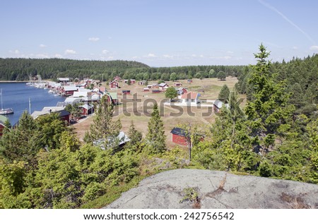 BALTIC SEA, SWEDEN ON JULY 22. View of a small village, harbor in sunshine on July 22, 2014 in Trysunda, Sweden. Small marina and red buildings in bright sunshine. Cliff this side.