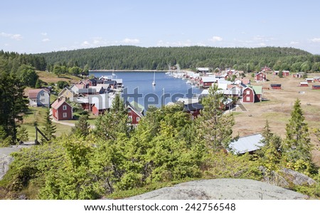 BALTIC SEA, SWEDEN ON JULY 22. View of a small village, harbor in sunshine on July 22, 2014 in Trysunda, Sweden. Small marina and red buildings in bright sunshine. Cliff this side.