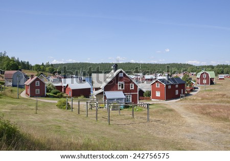BALTIC SEA, SWEDEN ON JULY 22. View of a small village, harbor in sunshine on July 22, 2014 in Trysunda, Sweden. Small marina and red buildings in bright sunshine. Lawn, grass this side.