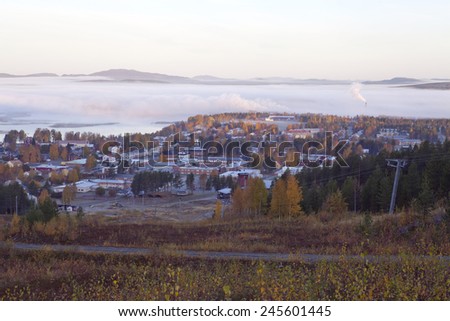MALA, SWEDEN ON OCTOBER 03. View of a small center in a community up North on September 30, 2014 in Mala, Sweden. Buildings, lake and fog just before sunrise. Ridges in the background.