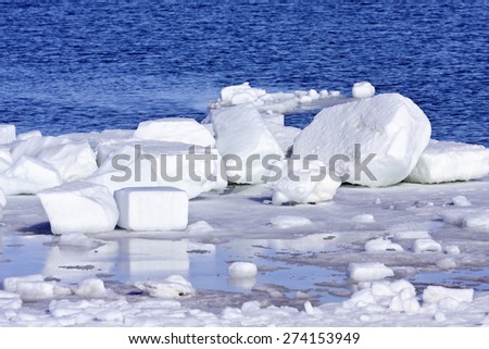 Blocks of ice and snow on the shore. The Baltic Sea in March during the day, hours when the ice at sea breaks up.