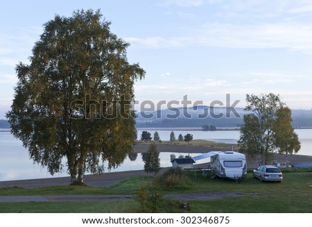 DALARNA, SWEDEN ON SEPTEMBER 07. Morning view of a campsite on September 07, 2013 in Dalarna, Sweden. Trees, beach, river and forest in the background. Some mist above the water.