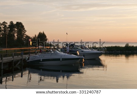 SILJAN, SWEDEN ON JULY 03. View of boats and people in a small harbor on July 03, 2015 in Siljan, Sweden. Beautiful evening by the lake. Chat and dinner.