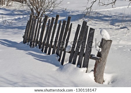Fragment of old broken wooden fence on the village outskirts