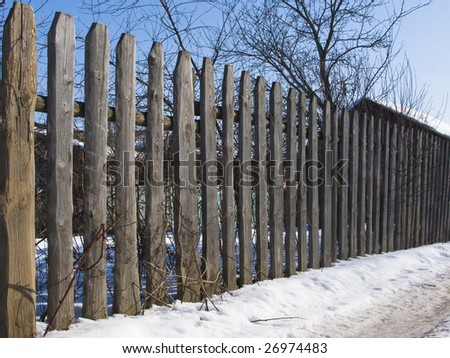 Fragment of aged natural dark wooden country fence