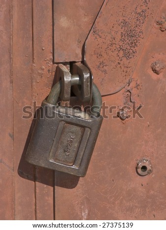 Red painted steel garage gate locked with padlock