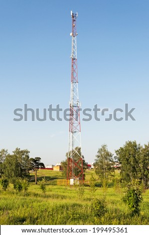 Cellular tower among the trees at the edge of the city