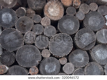 Stack of weathered round fire wood prepared for winter