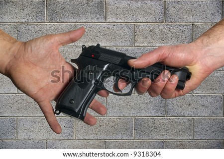 giving gun from hand to hand on grey wall background