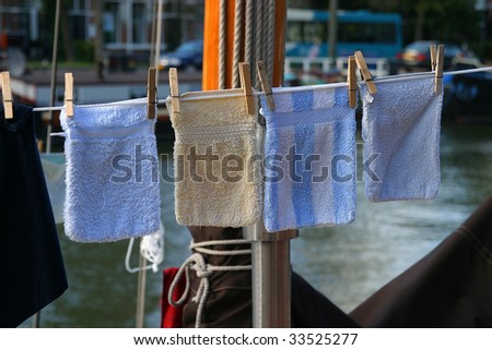 four wash clothes drying on a clothes line aboard a ship
