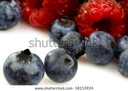 blue berries and raspberries on a white background