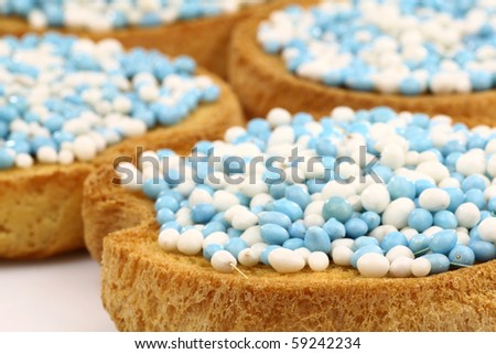 rusks with white and blue anise seed sprinkles served in Holland when a baby boy is born on a white background
