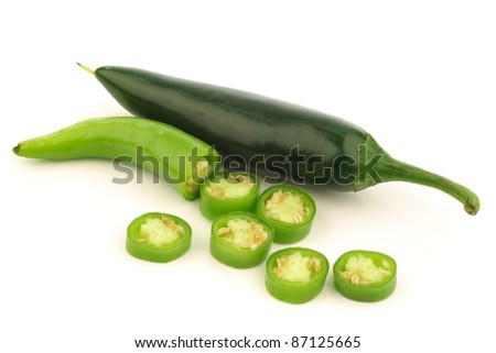 green peppers and a cut one on a white background