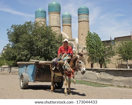 BUKHARA, UZBEKISTAN - MAY 20: Man with donkey-cart in front of madrassa Chor Minor on May 20, 2012 in Bukhara, Uzbekistan.