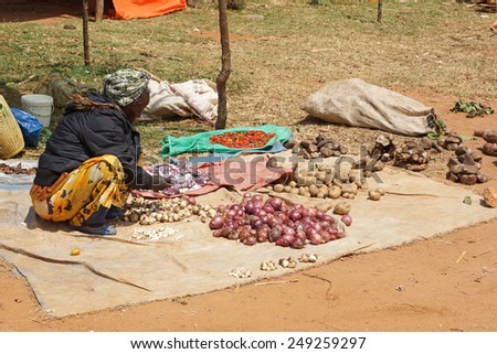 KEY AFER, ETHIOPIA - NOVEMBER 20, 2014: Old woman selling vegetables on the weekly market in Key Afer on November 20, 2014 in Key Afer, Ethiopia, Africa.