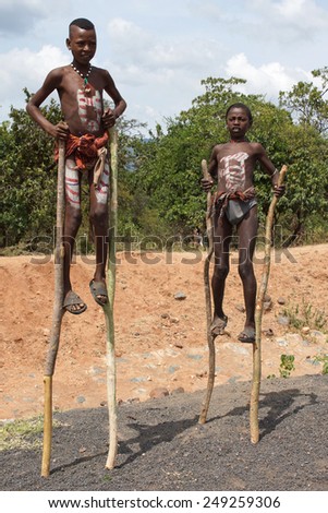 KEY AFER, ETHIOPIA - NOVEMBER 20, 2014: Benna children walking on stilts on November 20, 2014 in Key Afer, Ethiopia, Africa.