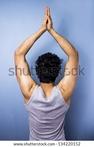 Young man in yoga pose of quiet meditation
