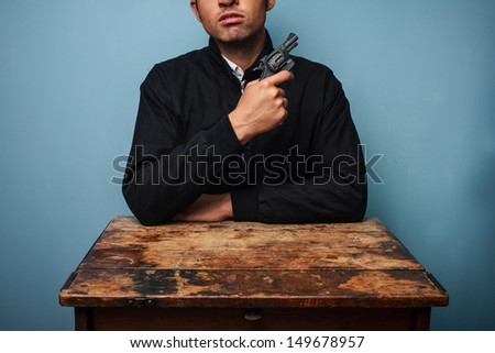 Thug at table with gun