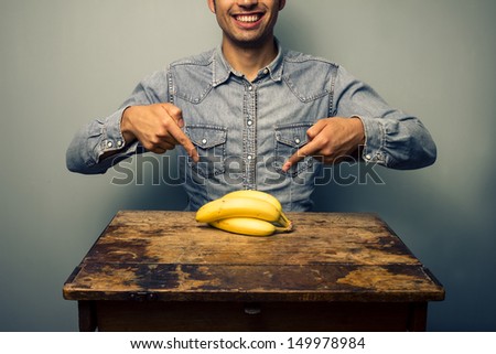Man pointing at bananas at old desk