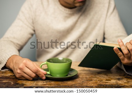 Man is reading and having coffee